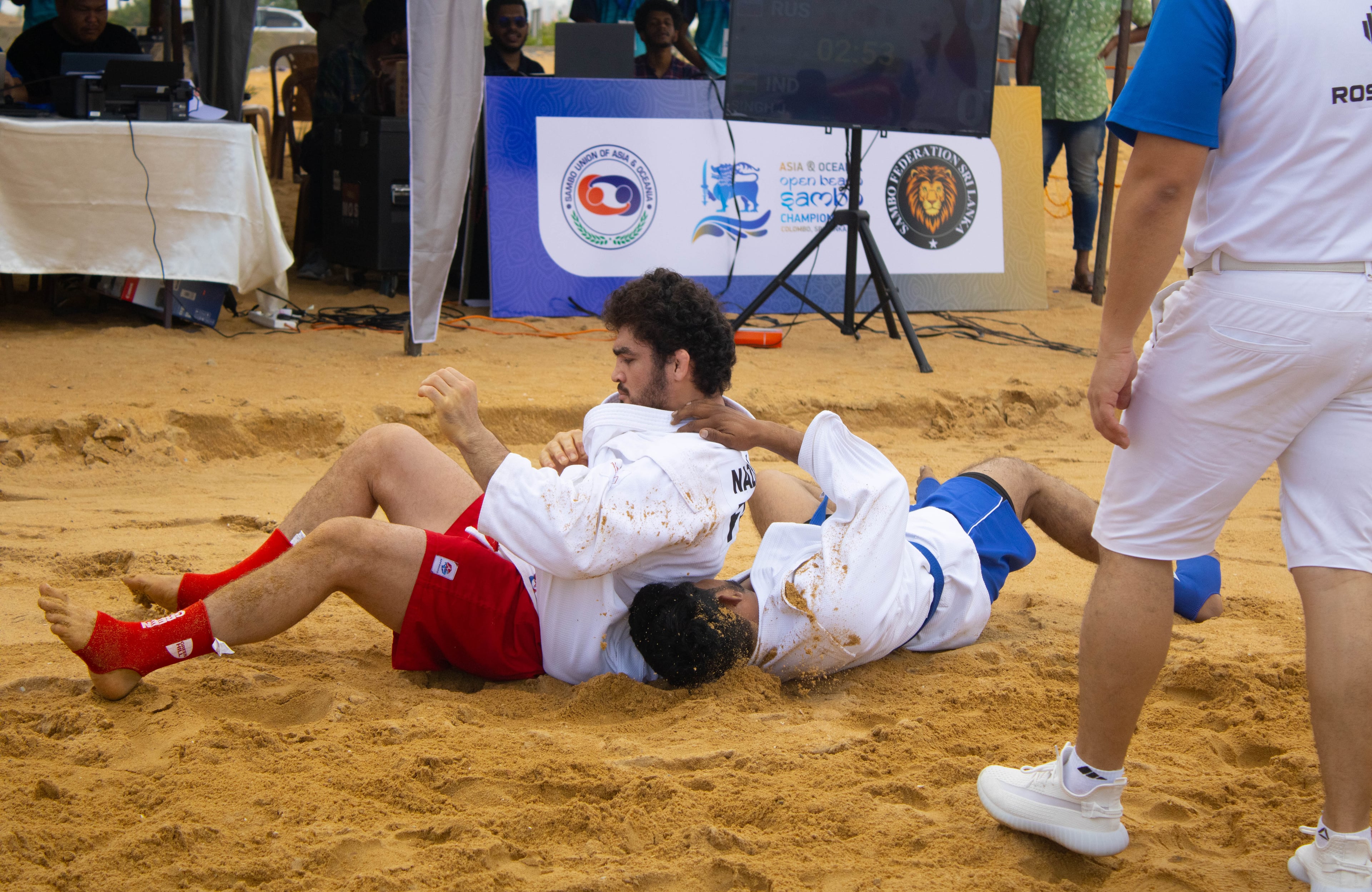 Two athletes locked on the ground during a championship bout
